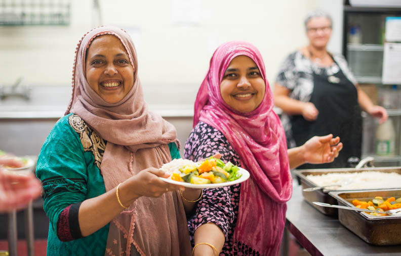 some women voluntering in a kitchen making meals