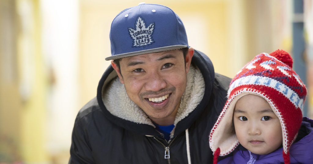 Father and son smiling in winter clothing