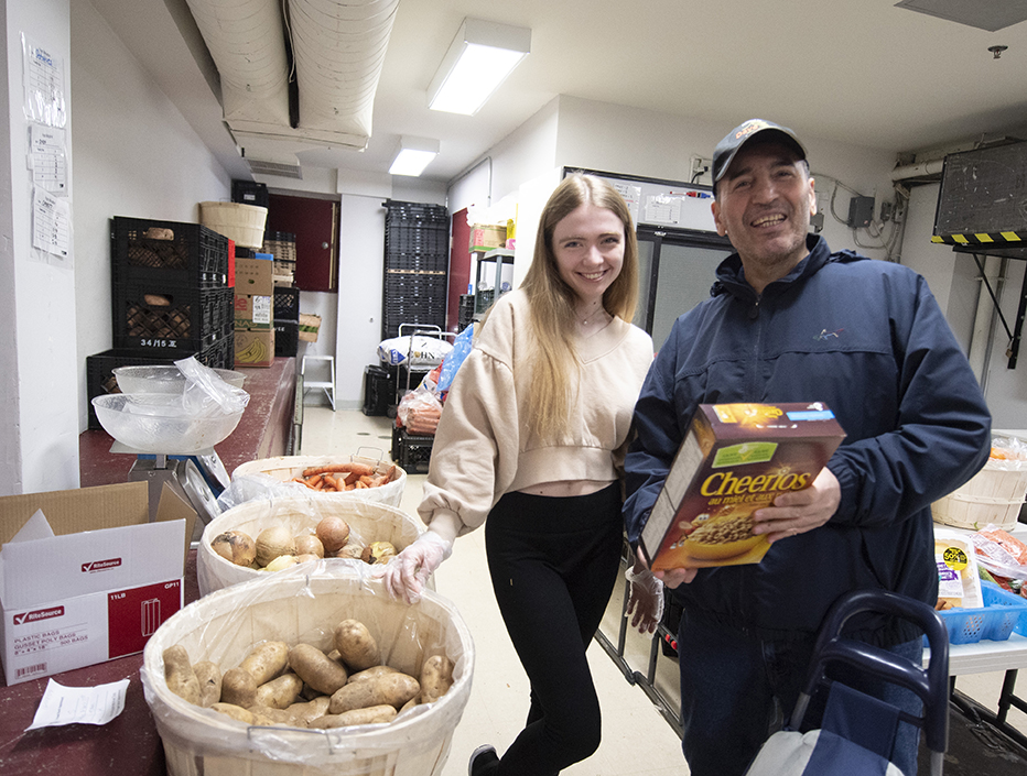 Volunteer helping a community member in the food bank