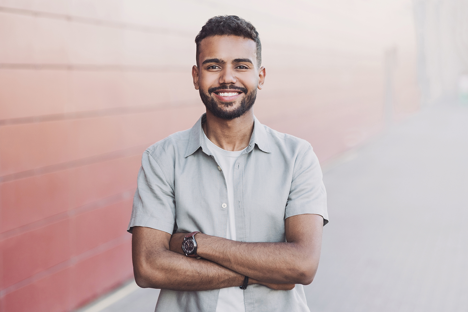 young man standing in front of brick wall