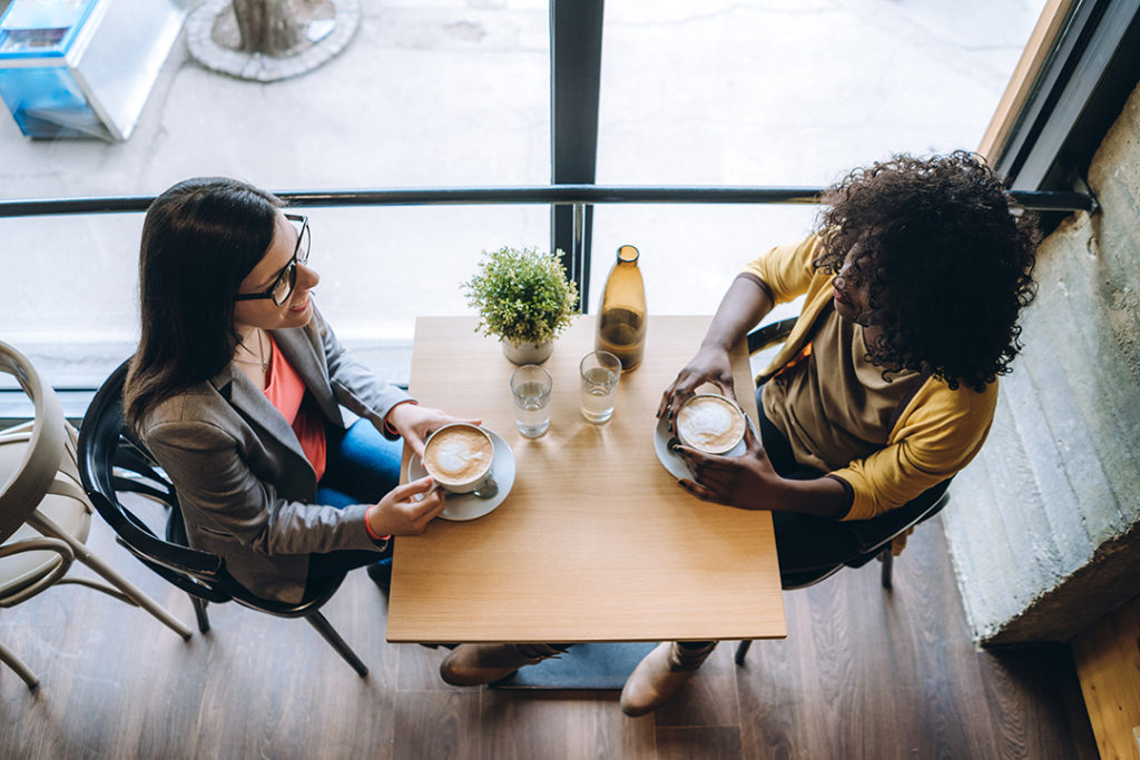 two women talking over coffee