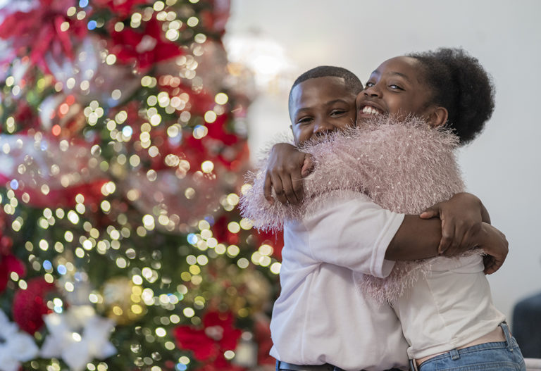 YSM's toy market. Happy kids hugging at Christmas from toy donations.