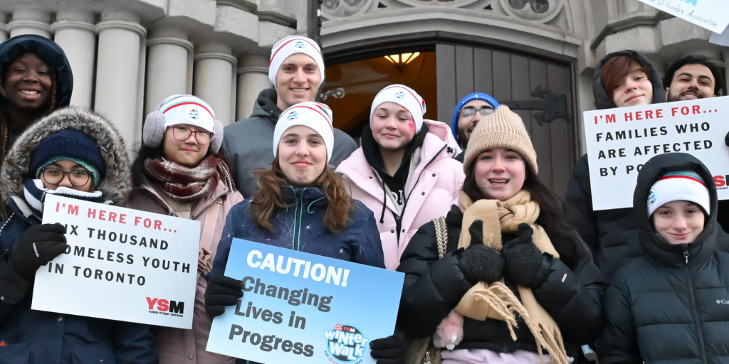 Young people holding signs at YSM's Winter Walk for Neighbours in Need